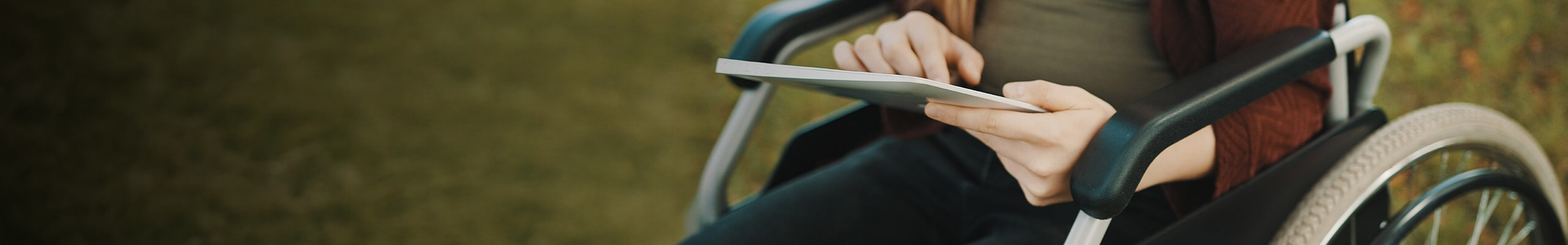 Hendikepirana oseba na vozičku uporablja tablico - desktop