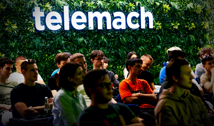 Udeležnci JobLaba sedijo v sejni med dogodkom za njimi vidna zelena stena in Telemach logo